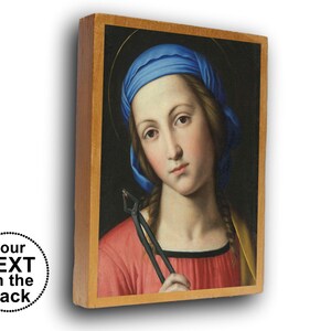 Peut inclure: Une plaque en bois rectangulaire représentant le portrait d'une personne portant un foulard bleu, un vêtement rouge et un châle jaune, tenant une pince en métal noir. L'image inclut un graphique circulaire avec le texte Your TEXT on the back.