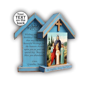 May include: A light blue wooden house-shaped plaque featuring a religious print of Saint Sophia and her children. The base includes the text St. Sophia, Pray For Us. The left side displays a birthday message ending with Love, Grandma Mary.