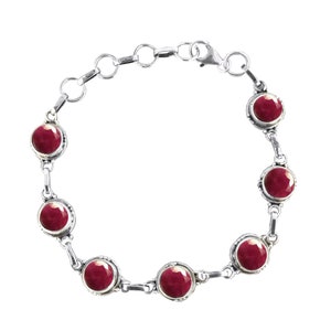 May include: A silver bracelet with a chain link design and six round red gemstones.