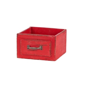 May include: A small, red wooden box with a drawer-like front. The box has a distressed finish, giving it a rustic appearance. A metal handle is attached to the front. The box is likely used for storage or decoration.