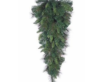 May include: A cascading, artificial evergreen swag with a metal loop for hanging. The swag is composed of dense, dark green pine needles and branches, creating a full, textured appearance. Ideal for holiday or seasonal decor.