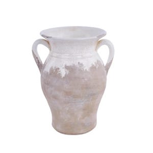 May include: A cream-colored ceramic vase with two handles. The vase has a distressed, aged appearance with a white top and a faded tan base. The vase has a wide mouth and a rounded body.