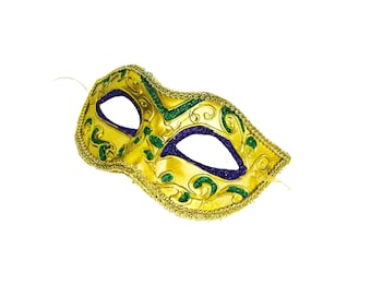 May include: A gold-colored masquerade mask with a decorative design. The mask features green and purple accents, with a gold trim and eye openings. The mask is designed to be worn at a masquerade ball or costume party.