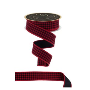 May include: A spool of D'LUX ribbon featuring a red and black buffalo check pattern. The ribbon is wound around a circular cardboard core with black and gold branding text. A length of the same red and black checkered ribbon extends below the spool.