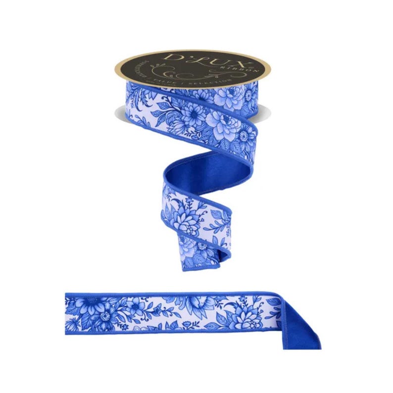 May include: A roll of D.Lux ribbon with a white background and a blue floral pattern. The ribbon is a wide, decorative style, with a solid blue backing. A section of the ribbon is unrolled, showing the pattern and the blue edge.