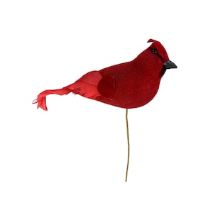 May include: A decorative red cardinal bird with a textured body, black beak, and a small crest. The bird has a feather tail and wing, and is attached to a thin, gold-colored wire stem.