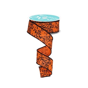 May include: Orange ribbon with a black floral pattern. The ribbon is on a spool with a teal label that reads "RG Ribbon". The ribbon is curled and ready to be used for crafts or decorations.