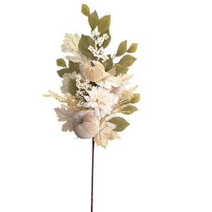Könnte beinhalten: Ein dekorativer Blumenstrauß mit zwei beigen Samtkürbissen, einer cremefarbenen Dahlienblüte in der Mitte, verschiedenen grünen und cremefarbenen Stoffblättern sowie kleinen weißen Beerenclustern an einem dünnen braunen Stiel.