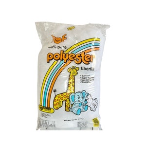 May include: A white bag of 100% pure polyester fiberfill. The bag has a rainbow design and features a giraffe, elephant, and bunny. The text on the bag reads "100% pure polyester fiberfill" and "Net Wt. 20 oz. (567g)".