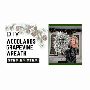 May include: DIY Woodlands Grapevine Wreath Step by Step. A woman holds a snowy white grapevine wreath decorated with pine cones and greenery.
