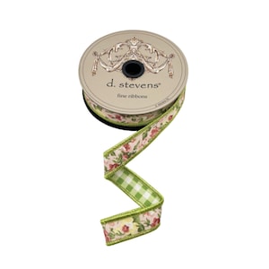 Puede incluir: Un carrete de cinta decorativa con un estampado floral y un diseño de cuadros de vichy verdes. La cinta es de d. stevens fine ribbons. La cinta tiene un borde cosido verde.