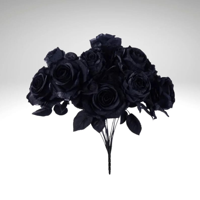 May include: A bouquet of black roses with dark green leaves and stems. The artificial flowers are clustered together, creating a full and dramatic arrangement. The roses are in full bloom, with detailed petals.