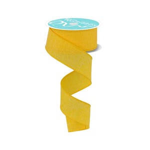 Peut inclure: Une bobine de ruban jaune vif à l'aspect texturé. Le ruban est déroulé, créant un motif ondulé et fluide. La bobine porte une étiquette bleu clair et blanche avec le texte "RG Ribbon".