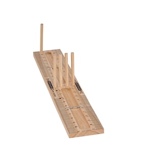 May include: A light-coloured wooden bow maker tool featuring a rectangular base with printed metric measurements and four vertical dowels. The surface displays the text Bow & Go, providing a structured guide for crafting bows with precise spacing.