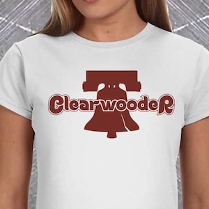 May include: White t-shirt with a red graphic of the Liberty Bell and the text "ClearwoodeR". The back of the shirt has a red "P" with a white baseball inside.
