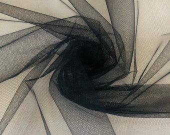 Peut inclure: Tulle noir avec une texture fine en maille. Le tissu est drapé et plié, révélant sa nature douce et délicate.