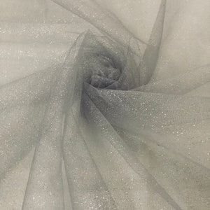 May include: Silver glitter tulle fabric. The fabric is sheer and has a delicate sparkle.