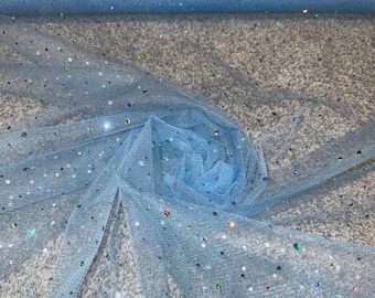 May include: A roll of light blue tulle fabric with iridescent glitter. The fabric is partially unrolled, revealing a delicate, sheer texture. The glitter sparkles, adding a touch of shimmer. Ideal for crafting, this fabric is perfect for creating dresses, veils, or decorations.
