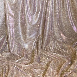 May include: A close-up of a gold sparkly fabric with a textured, crinkled surface.