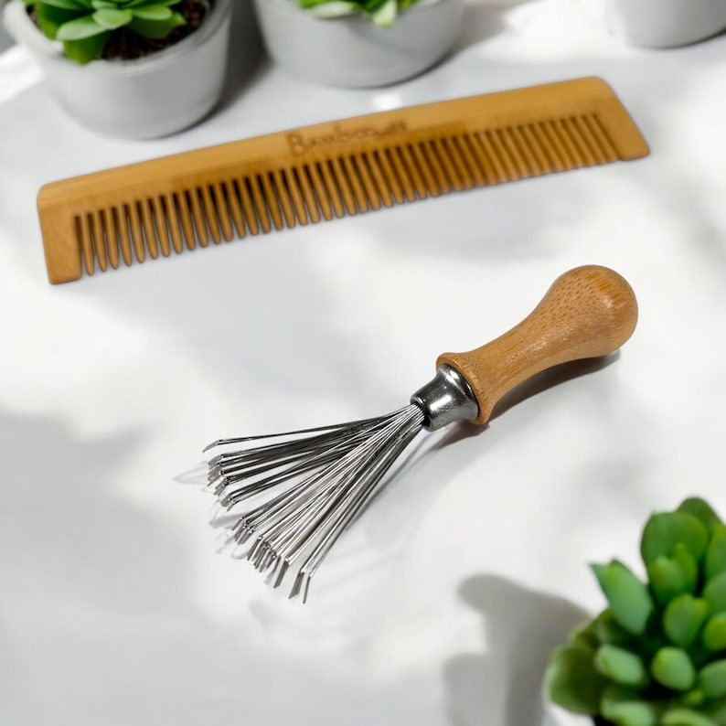 May include: A wooden comb and a brush cleaner tool are shown on a white surface. The comb is made of light brown bamboo with fine teeth. The brush cleaner has a wooden handle and metal bristles. The word "Bamboo" is visible on the comb.