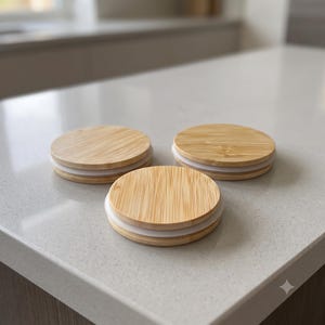 Puede incluir: Tres tapas circulares de bamb&uacute; con un acabado de veta de madera marr&oacute;n claro y un anillo de sellado de silicona blanca en el borde. Cada tapa es plana en la parte superior con una superficie lisa, dise&ntilde;ada para encajar firmemente.