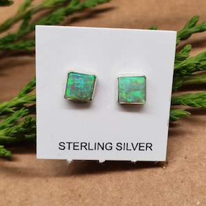 May include: A pair of sterling silver earrings with square green opal stones.