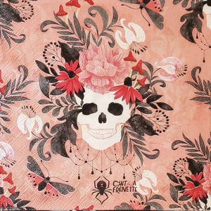 May include: A pink and black floral design with a white skull in the center. The skull is surrounded by red flowers and black leaves. The design is on a pink background with the text "CYNT & A FRENETTE" at the bottom.