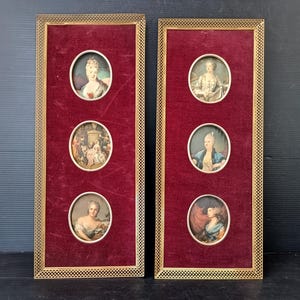 May include: Two framed antique portrait miniatures. Each frame has a gold filigree border, a deep red velvet backing, and three oval portraits. The portraits depict women in period clothing.