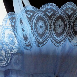 May include: Light blue lace trim with a scalloped edge and floral pattern.
