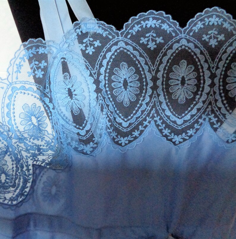 May include: Light blue lace trim with a scalloped edge and floral pattern.