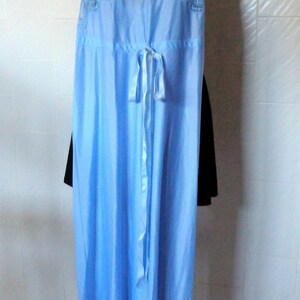 May include: A light blue satin nightgown with a lace trim and a bow at the waist.