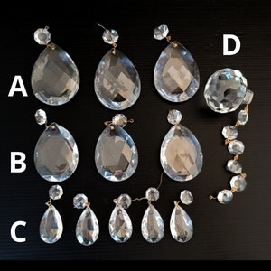 Peut inclure: Assortiment de pampilles et de perles de lustre en cristal transparent. Les pampilles sont en forme de goutte d'eau avec des surfaces à facettes, et les perles sont rondes. Chaque pièce a une petite boucle métallique pour la suspension.