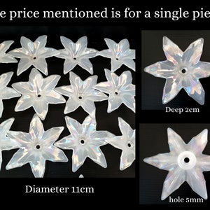 Può includere: Elementi decorativi iridescenti a forma di stella. L'immagine mostra più pezzi, con un diametro di 11 cm e una profondità di 2 cm. Ogni pezzo ha un foro di 5 mm al centro. Il testo indica che il prezzo è per un singolo pezzo.