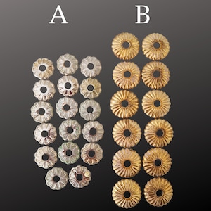 May include: Two sets of decorative metal bead caps. Set A features silver-toned bead caps with a floral design. Set B features gold-toned bead caps with a similar floral design. The bead caps are arranged on a dark gray gradient background.