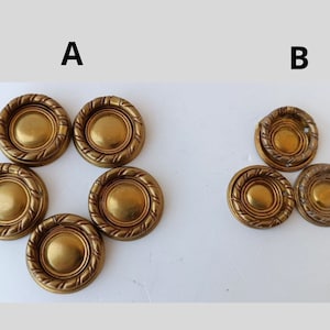 May include: A collection of antique brass drawer pulls. The pulls have a circular design with a central disc and a rope-like border. The image is divided into two groups, labeled A and B, showcasing the pulls.