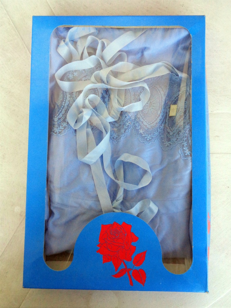 May include: A blue lace nightgown with a white ribbon, packaged in a blue box with a red rose illustration.