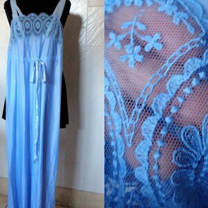 May include: A light blue, floor-length slip dress with delicate lace trim around the neckline and straps. The dress has a tie at the waist.