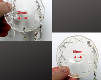 May include: Clear glass chandelier parts with decorative edges and hanging crystal pendants. One part measures 25mm across, the other 15mm. These parts are designed for chandeliers and other lighting fixtures.