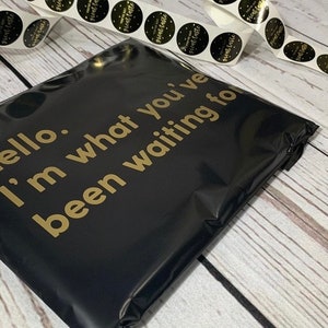 May include: Black poly mailer with gold text that reads "hello. i'm what you've been waiting for".