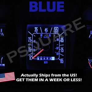 May include: A blue LED gauge kit for a classic car dashboard. The gauges feature a blue backlight and white numbers. The speedometer reads up to 85 mph and has a red needle. The gauges are labelled with the words "NORMAL" and "UNLEADED GASOLINE ONC".