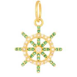 May include: Gold-tone pendant charm in the shape of a ship's wheel with green and white gemstones.