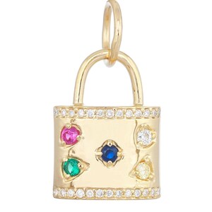 May include: A gold padlock charm featuring a row of small clear stones along the top and bottom edges. The center of the padlock is set with a blue stone, surrounded by four smaller stones in pink, green, white, and yellow, each in a bezel setting.