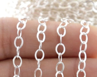 Puede incluir: Cadena de plata con múltiples hebras de eslabones redondos. La cadena se sostiene en una mano.