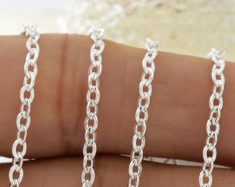 May include: Silver chain, a close-up of a silver chain on a hand, the chain is about 1 mm thick and has a delicate, oval link pattern.