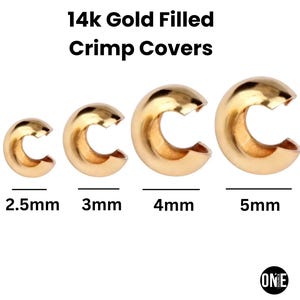 May include: Four gold-filled crimp covers in varying sizes: 2.5mm, 3mm, 4mm, and 5mm. The text "14k Gold Filled Crimp Covers" is displayed above the crimp covers. The crimp covers are arranged in a row against a white background.
