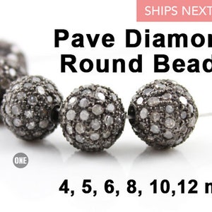 May include: A strand of round pave diamond beads in various sizes, including 4mm, 5mm, 6mm, 8mm, 10mm, and 12mm. The beads are silver in color and have a sparkly, diamond-like finish.