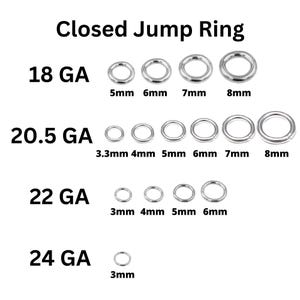 May include: Assortment of closed jump rings in various sizes and gauges. The rings are made of silver metal. The sizes are labeled in millimeters. 18 GA: 5mm, 6mm, 7mm, 8mm. 20.5 GA: 3.3mm, 4mm, 5mm, 6mm, 7mm, 8mm. 22 GA: 3mm, 4mm, 5mm, 6mm. 24 GA: 3mm.