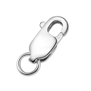 Puede incluir: Un cierre de langosta plateado brillante con un peque&ntilde;o anillo. El cierre tiene un dise&ntilde;o curvo y una palanca para abrir y cerrar. El n&uacute;mero "925" est&aacute; estampado en el cierre. Este cierre de joyer&iacute;a se utiliza para collares y pulseras.