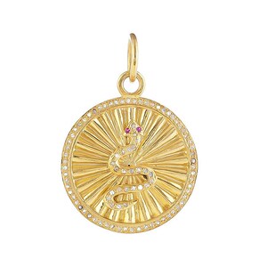Puede incluir: Collar con colgante de oro redondo con un diseño de serpiente con detalles de diamantes y ojos de rubí.