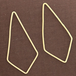 May include: A pair of gold-toned geometric earrings with a diamond shape.